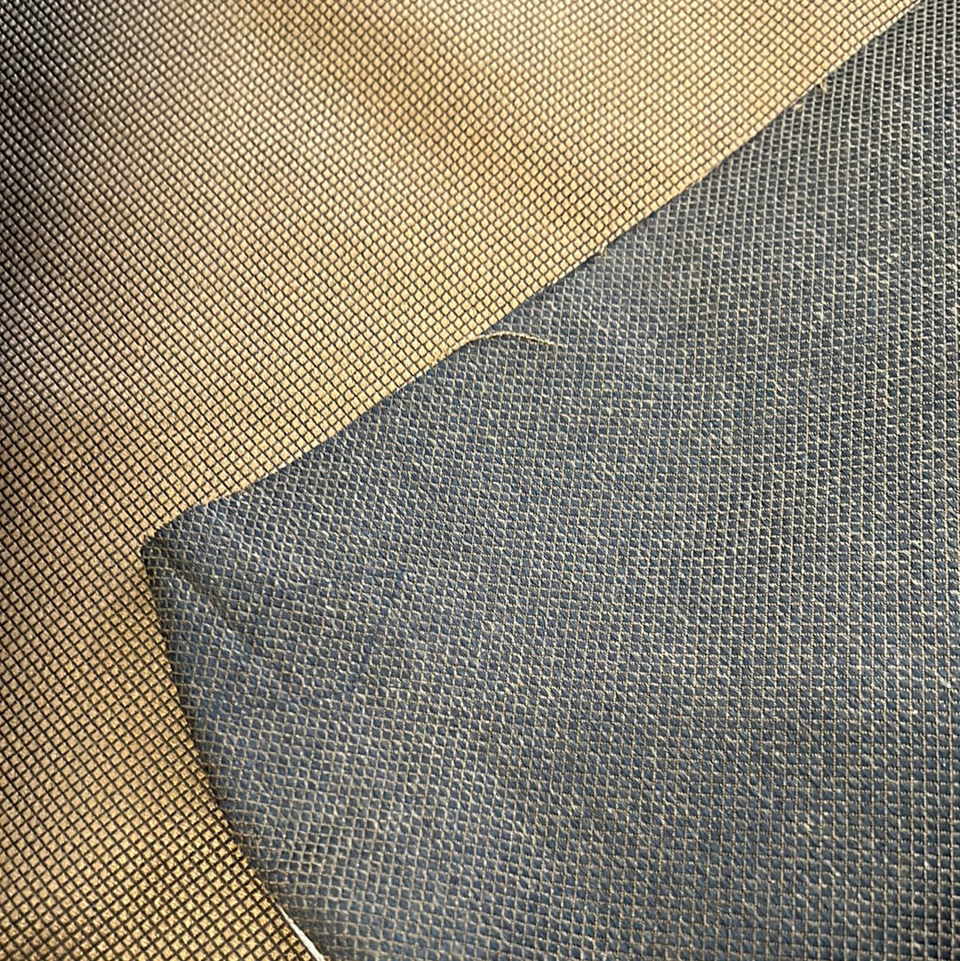 Close-up of textured fabric swatches, one beige and one dark gray, showing detail of woven patterns.