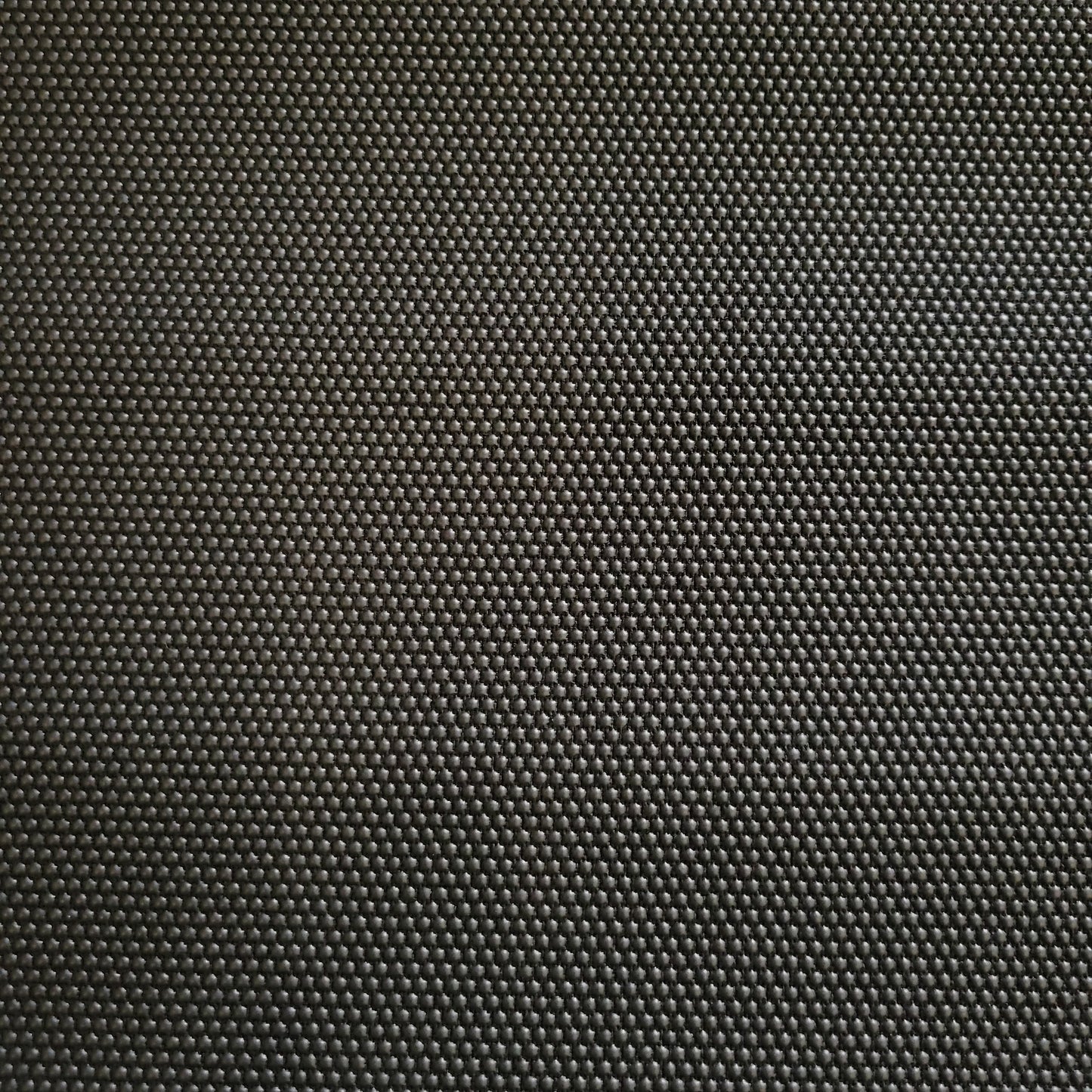 Close-up of dark gray Super Fabric 1, textured with small, raised dots.