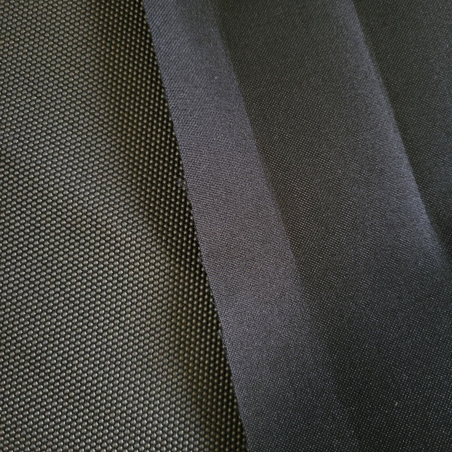 Close-up of dark gray textured fabrics, showing a comparison of two distinct weaves.