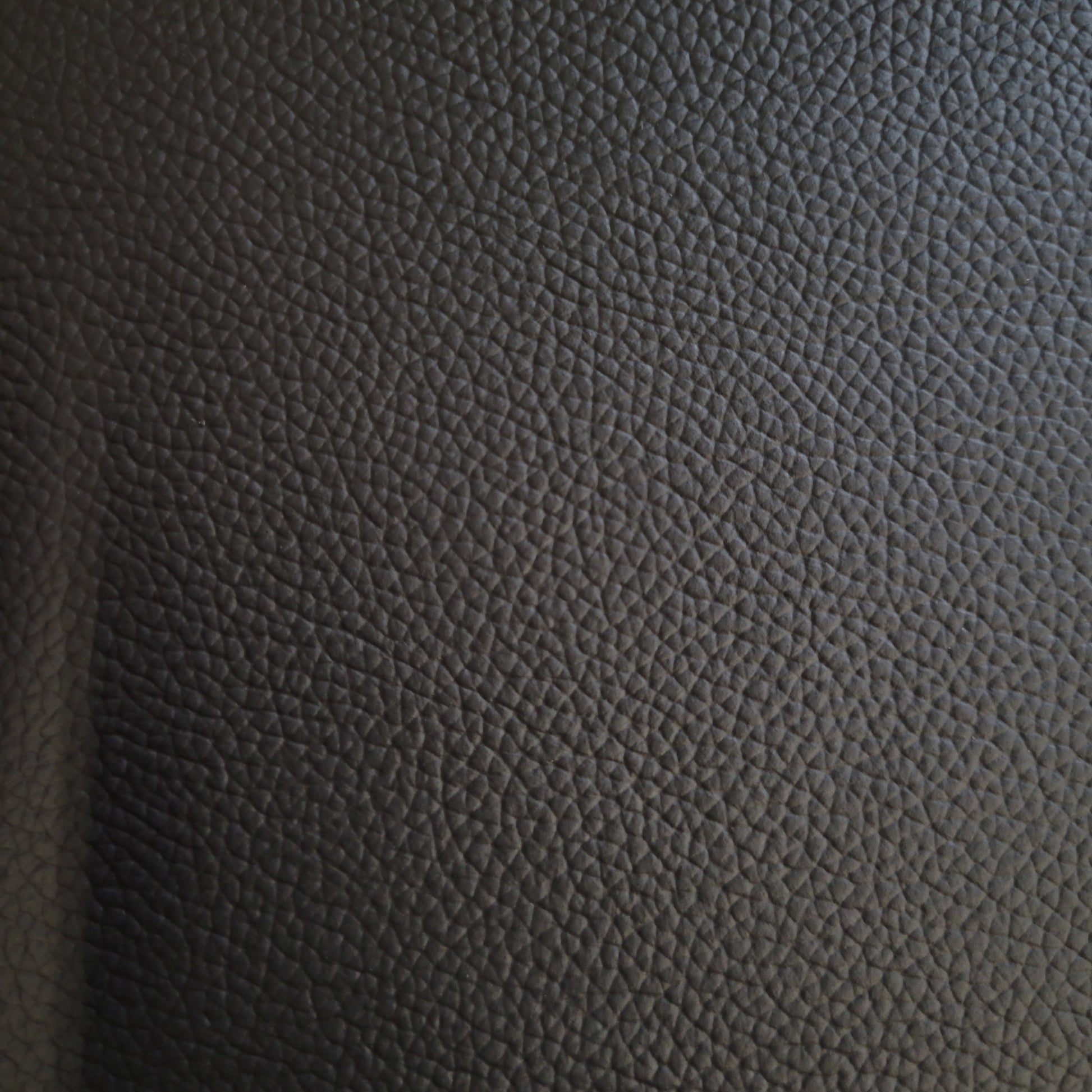 Close-up of dark gray pebbled leather hide.