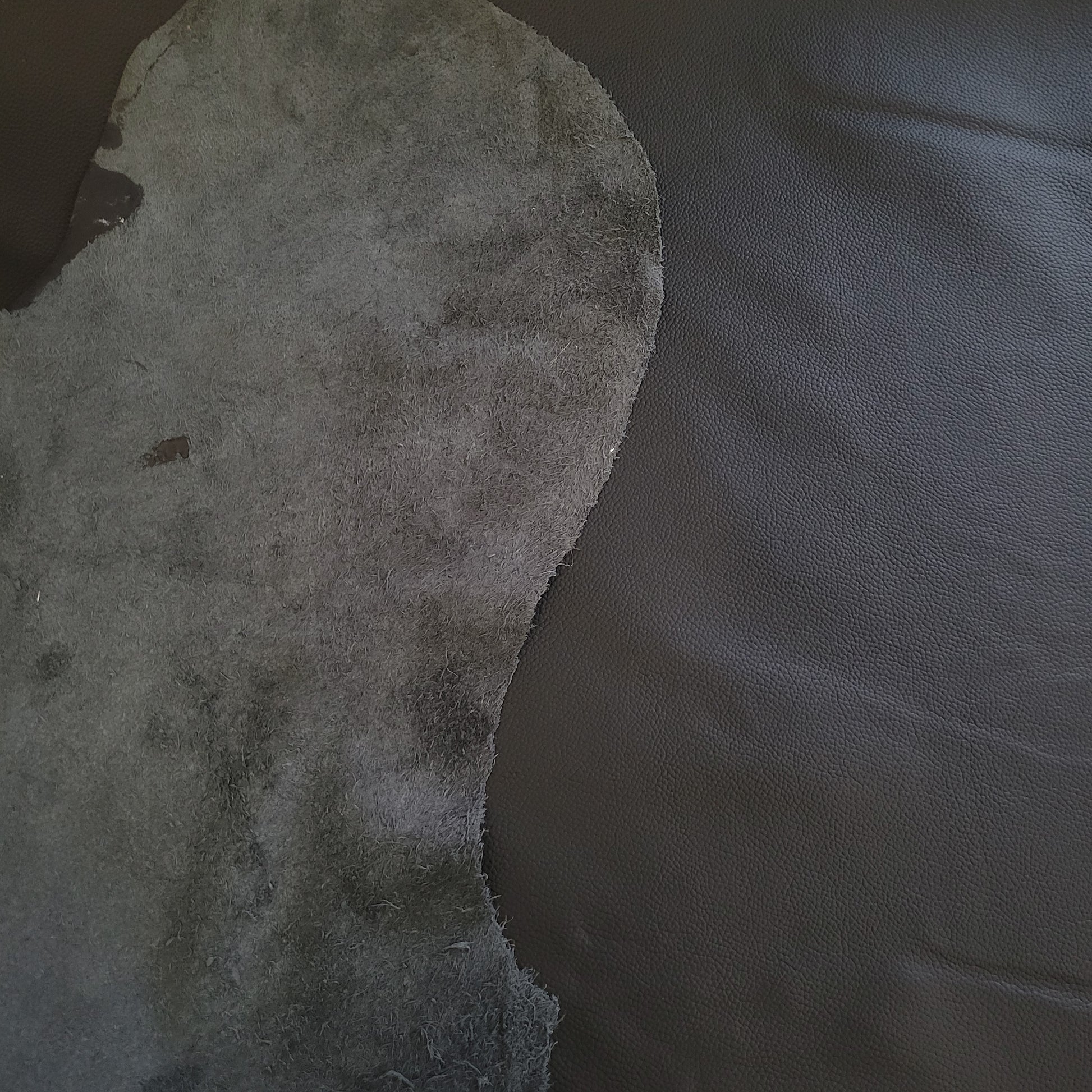 Dark gray leather hide sample shown alongside finished dark gray leather.
