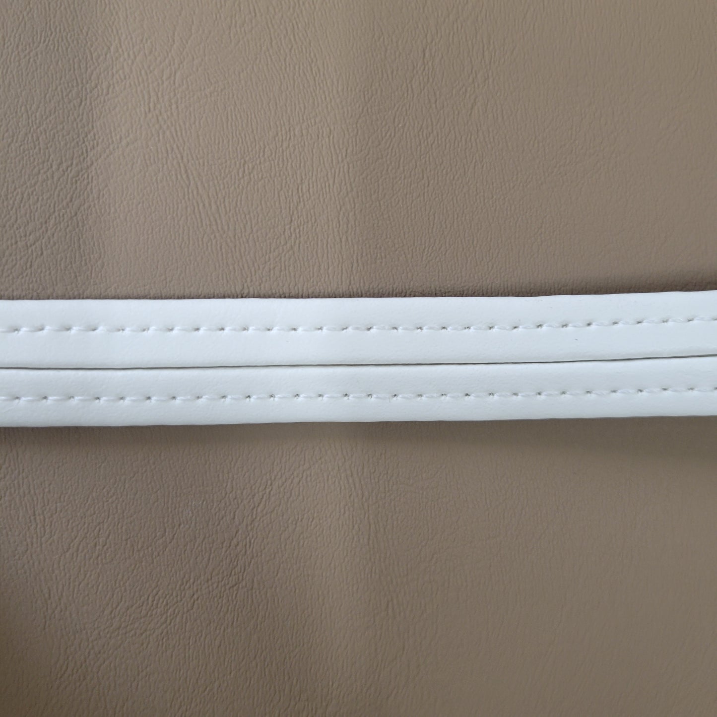 Close-up of beige vinyl with a white welt detail.
