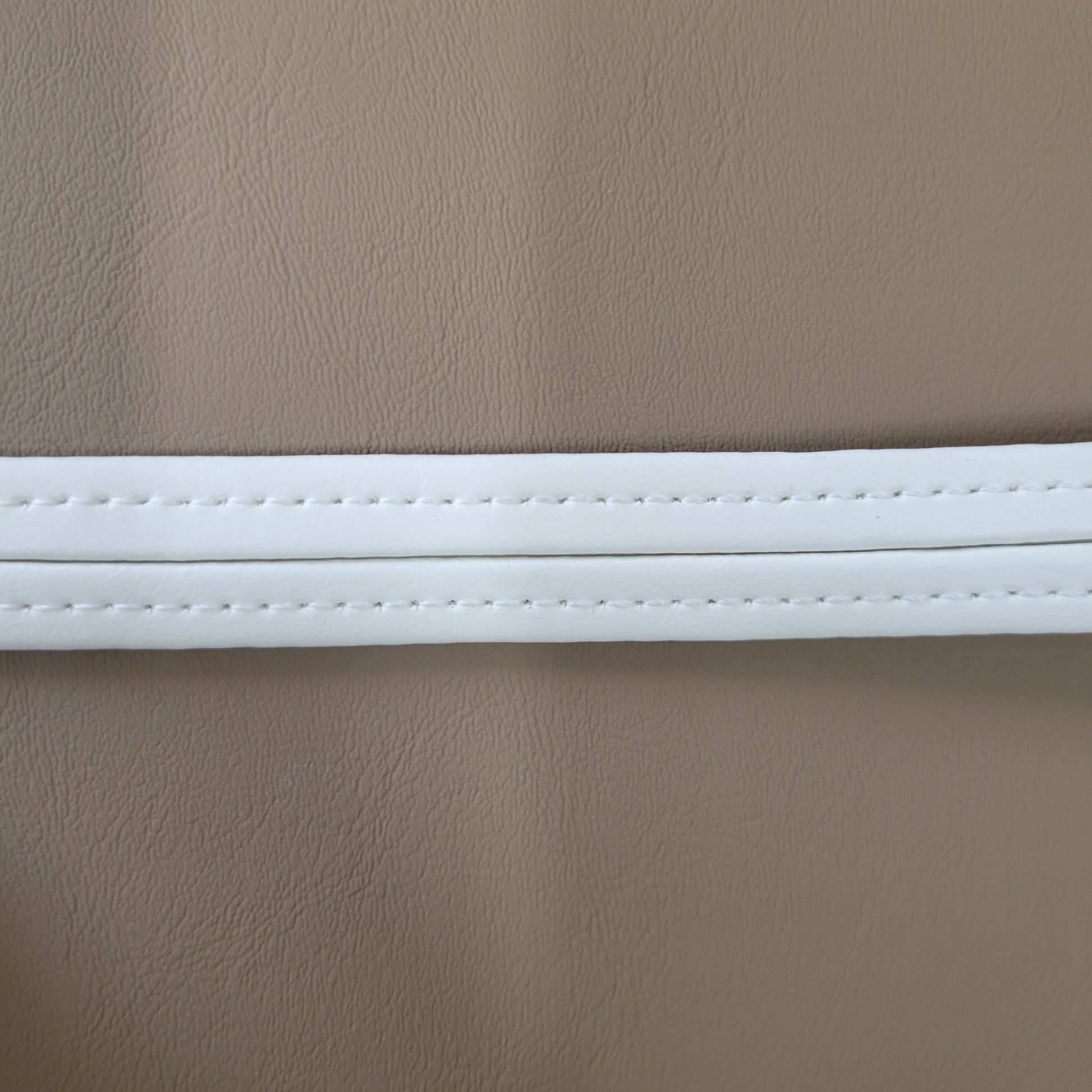 Close-up of beige vinyl with a white welt detail.