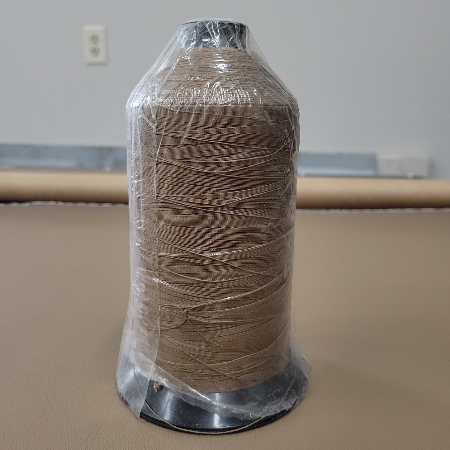 Sunguard B92 Saddle 231Q 16oz thread spool, tan color, for upholstery projects.