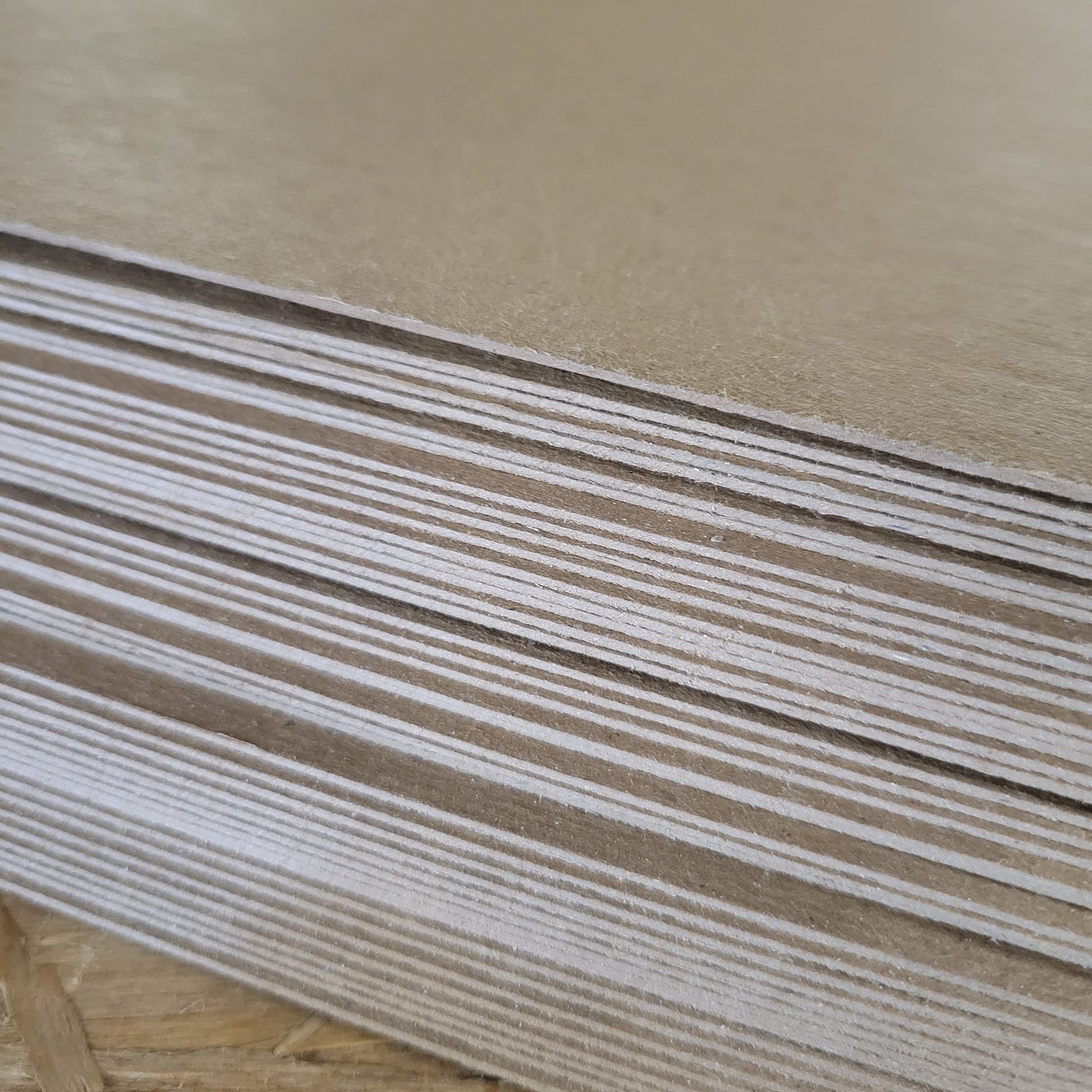 Stack of light brown visor boards, showing layered construction.