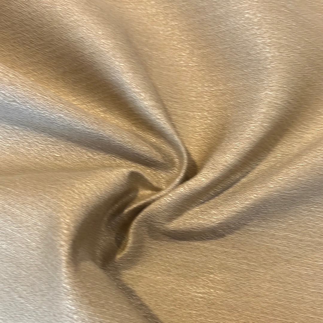 Close-up of gold fabric with subtle texture, showing its drape and luxurious feel.