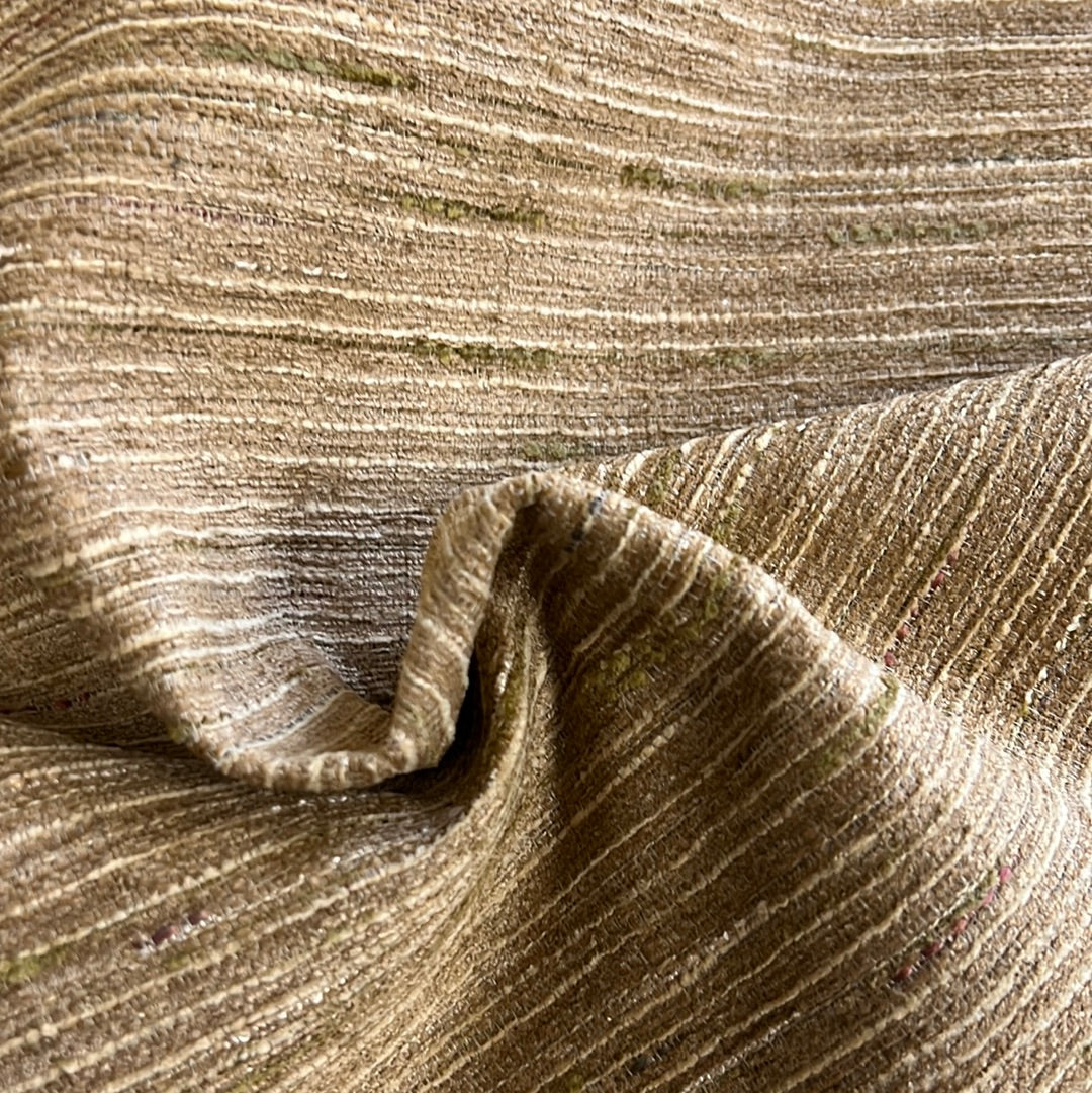 Close-up of taupe textured fabric with subtle green accents, showcasing its drape and subtle sheen.
