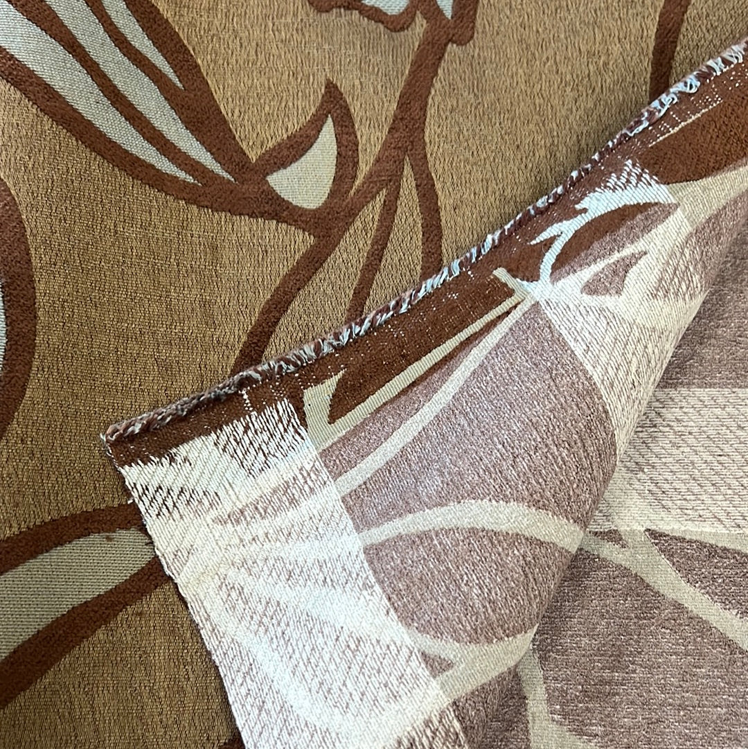 Close-up of brown and beige patterned fabric, showcasing texture and design detail.