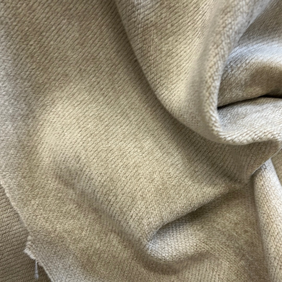 Close-up of light beige textured fabric, showing its soft, slightly ribbed surface.
