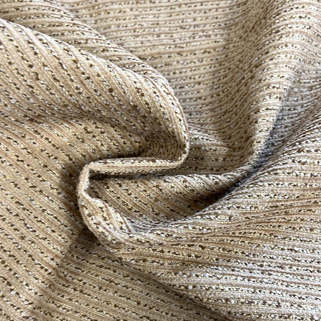 Close-up of beige ribbed fabric with subtle textural detail.