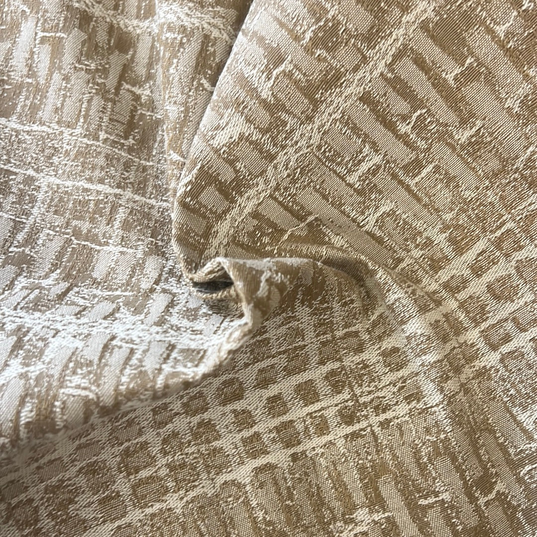 Close-up of beige fabric with an embossed geometric pattern.