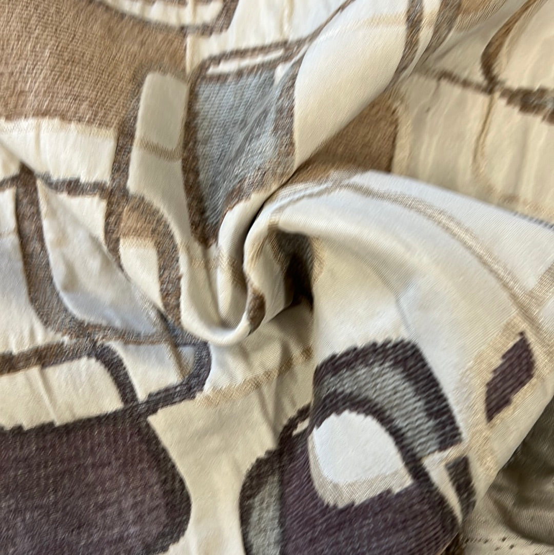 Cream fabric with brown and gray abstract print, textured weave.
