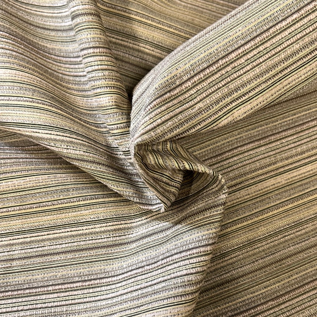 Close-up of beige fabric with thin, multicolored stripes.