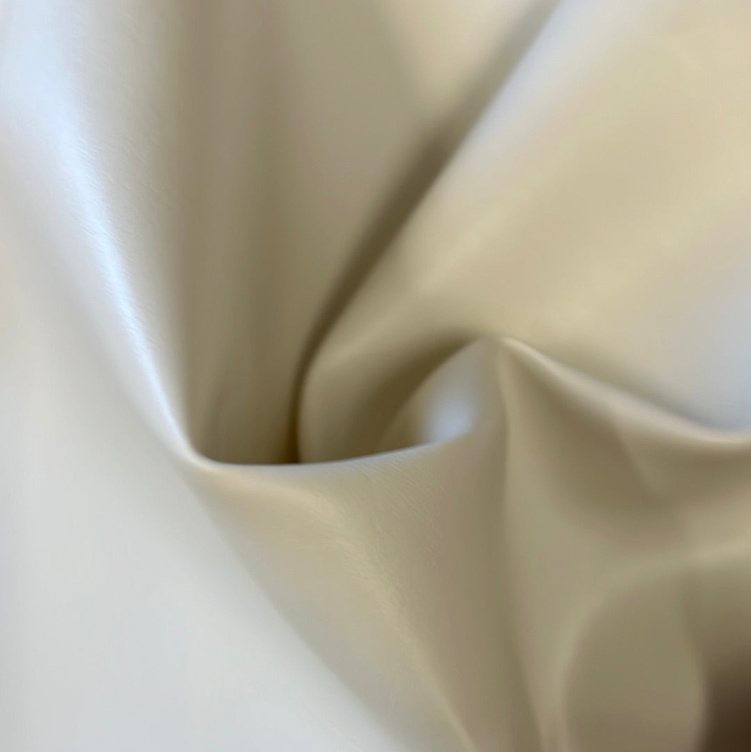 Cream-colored vinyl fabric swatch, showing texture and drape.