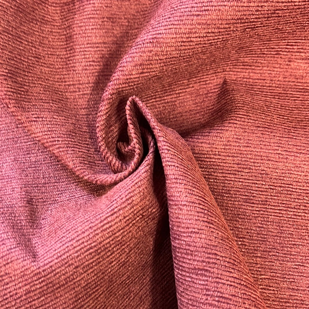 Close-up of rich, reddish-brown corduroy fabric, subtly textured.
