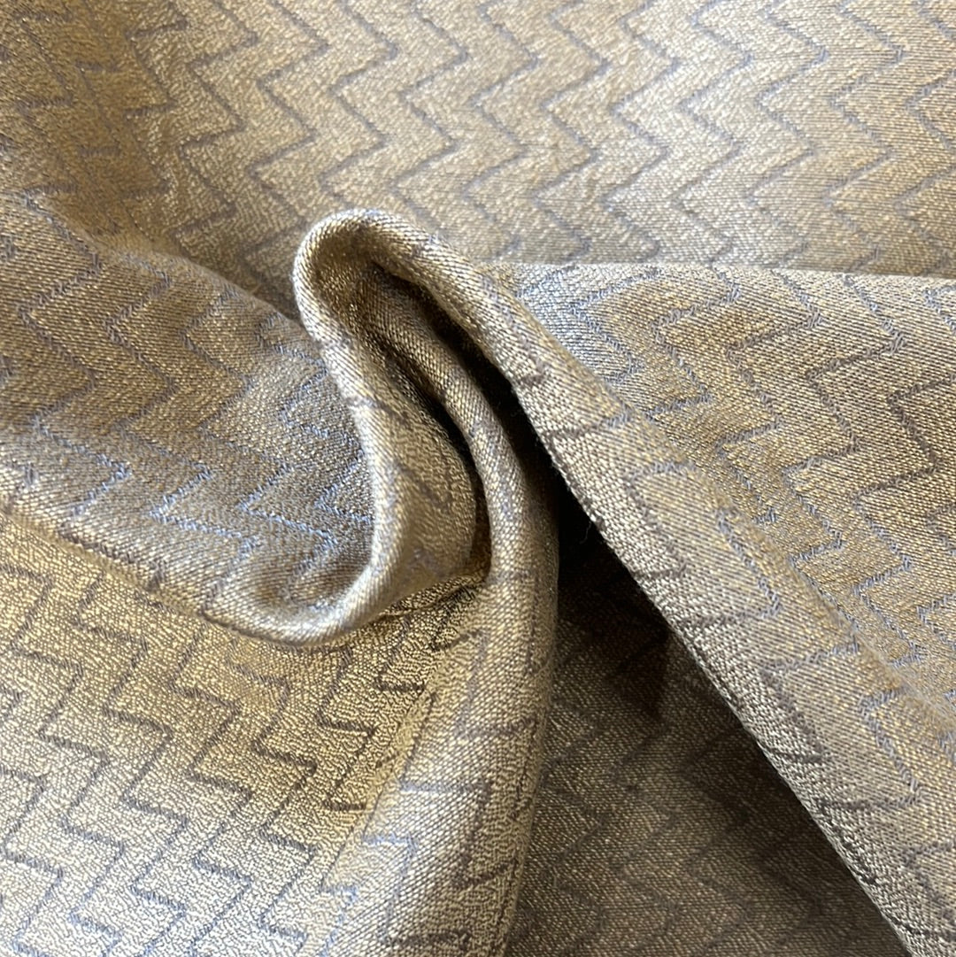 Gold fabric swatch with subtle geometric pattern, showcasing texture and drape.