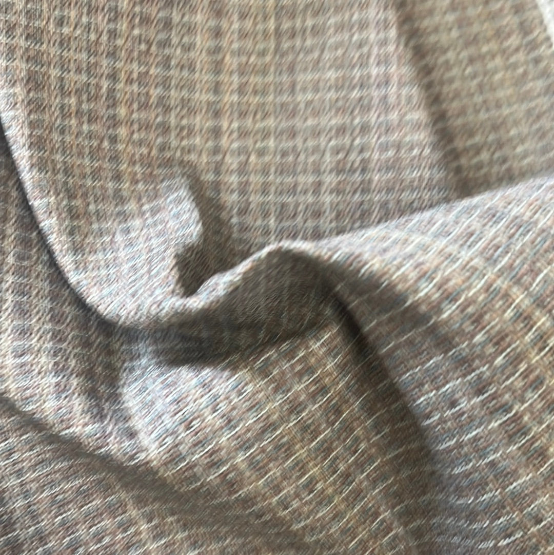 Close-up of textured fabric in muted browns and beiges, showcasing a subtle grid pattern.