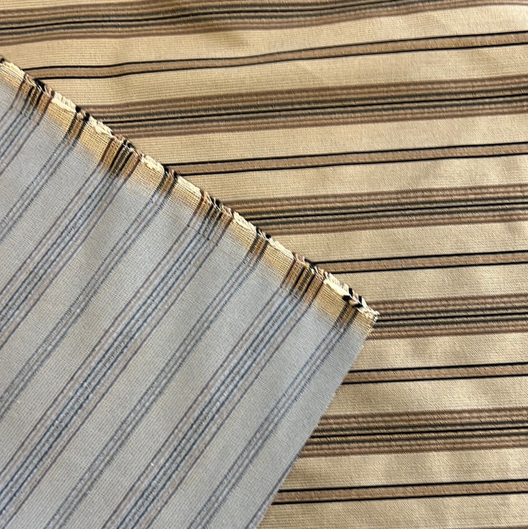 Close-up of beige and brown striped fabric samples, showcasing different stripe widths and tones.