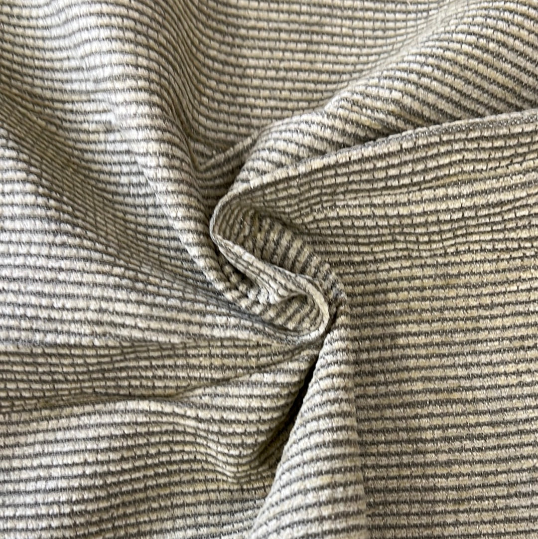 Cream-colored fabric swatch with thin, dark brown stripes, showing texture and drape.