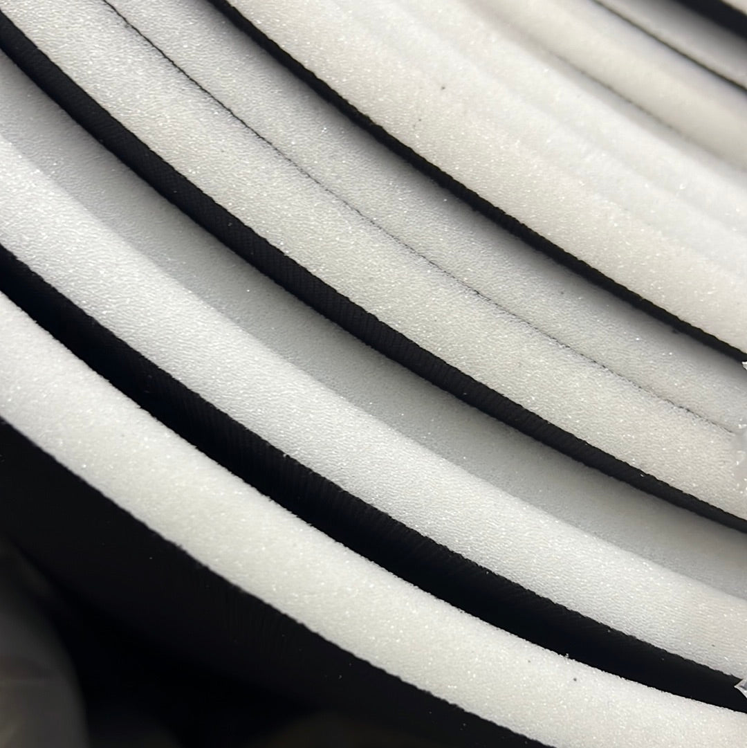 Close-up of half-inch sew foam rolls, showcasing textured white foam with black backing.
