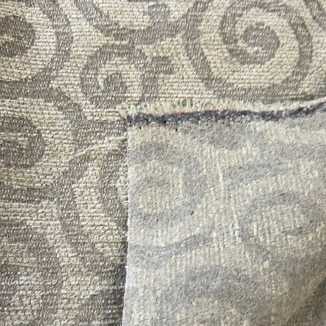 Close-up of neutral-toned rug showing detailed texture and pattern.