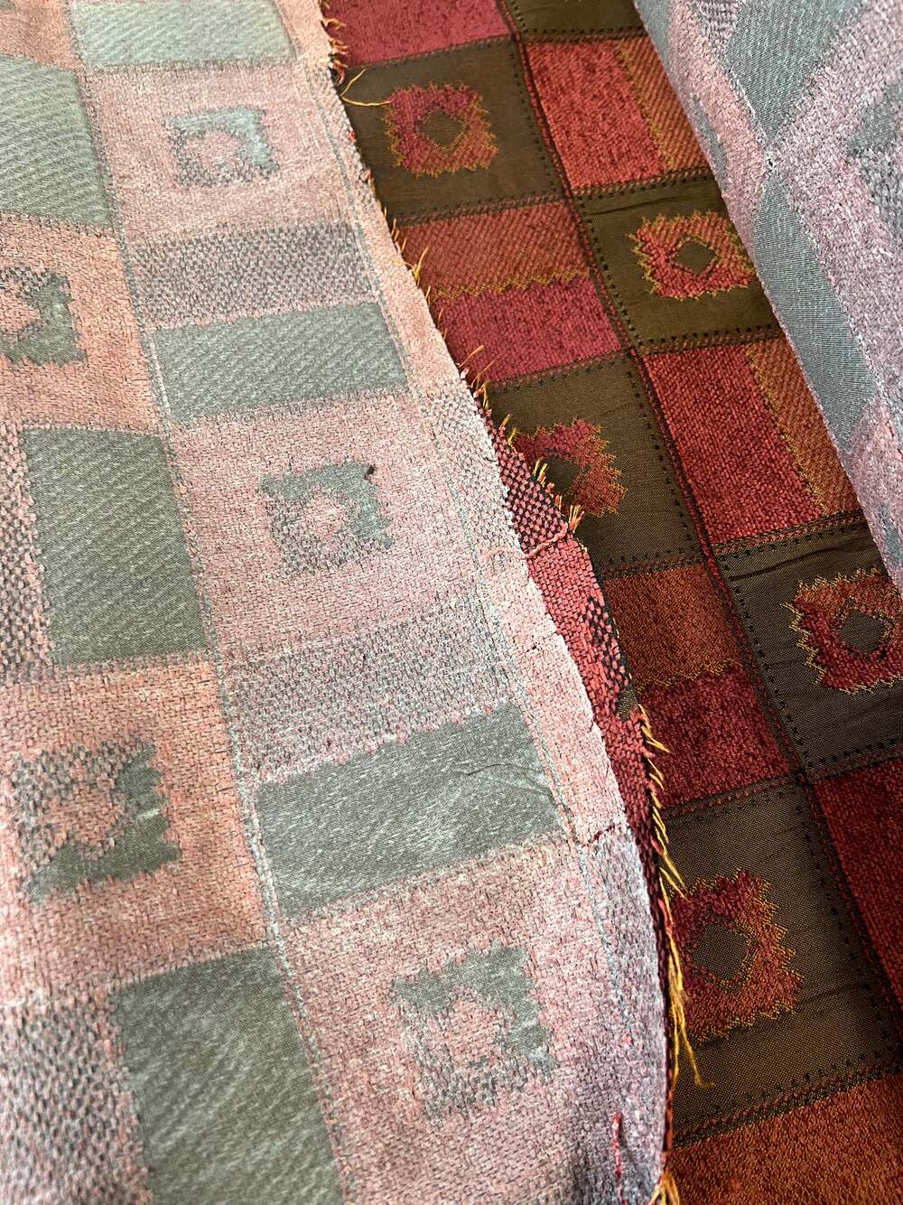 Burgundy and gray patterned upholstery fabric swatches.