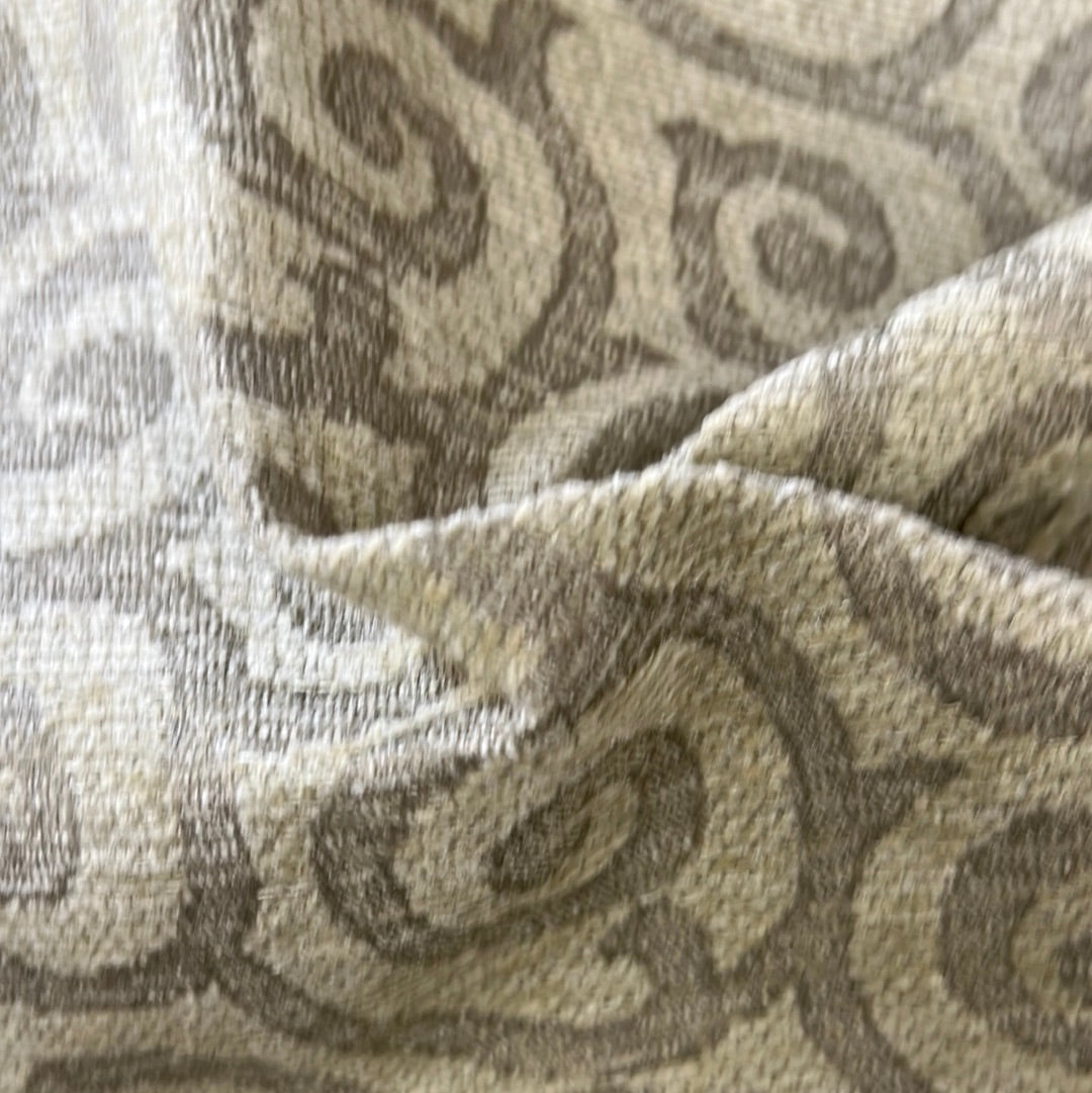 Textured beige fabric with a subtle swirling pattern.