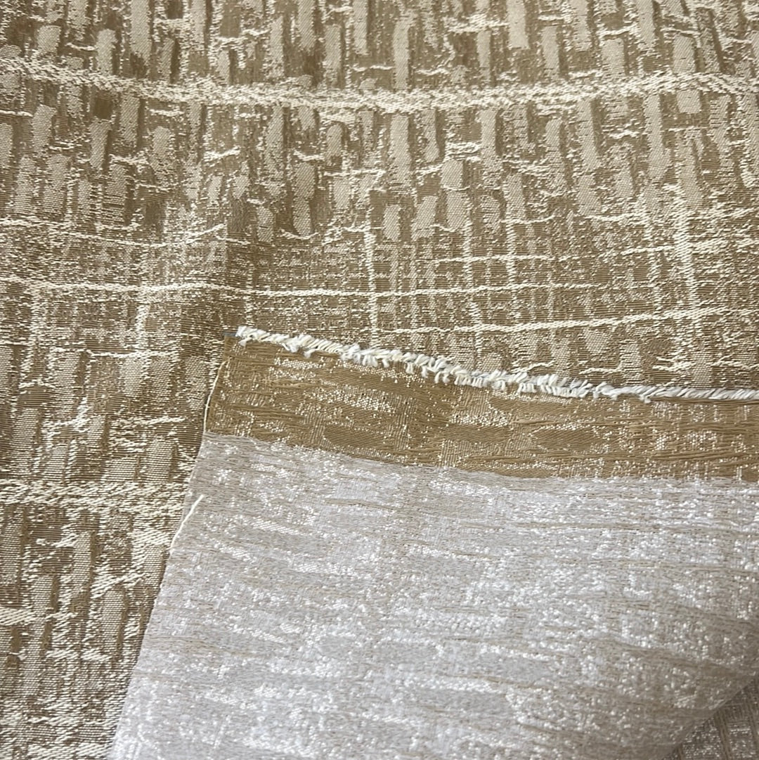 Beige and gold textured fabric swatch with geometric pattern.