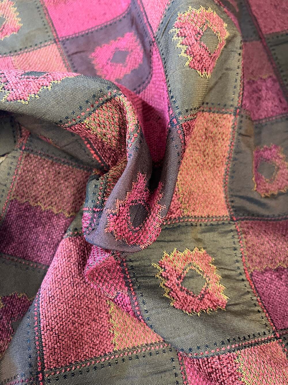 Burgundy patterned fabric swatch, close-up showing textured weave and color details.