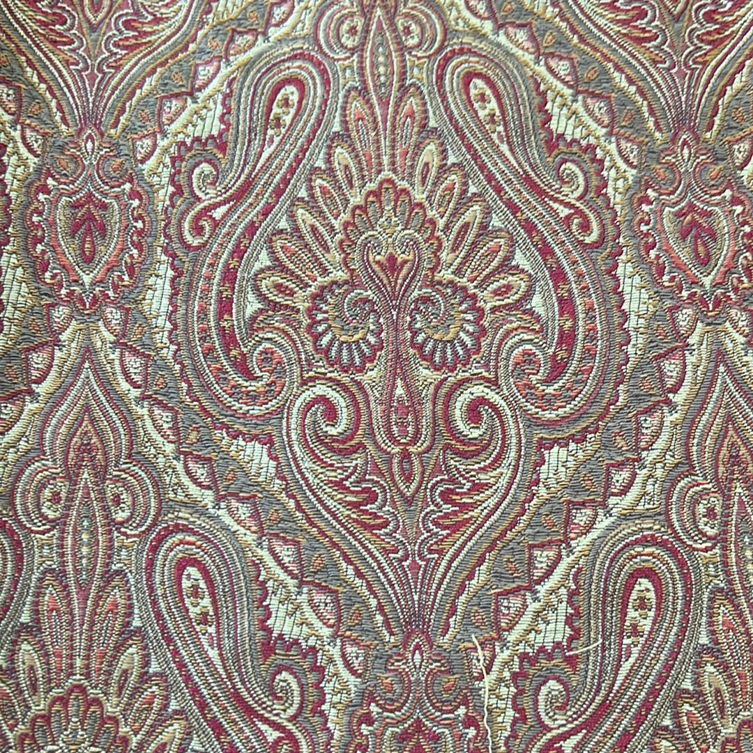 Intricate paisley upholstery fabric in red, beige, and gray tones.