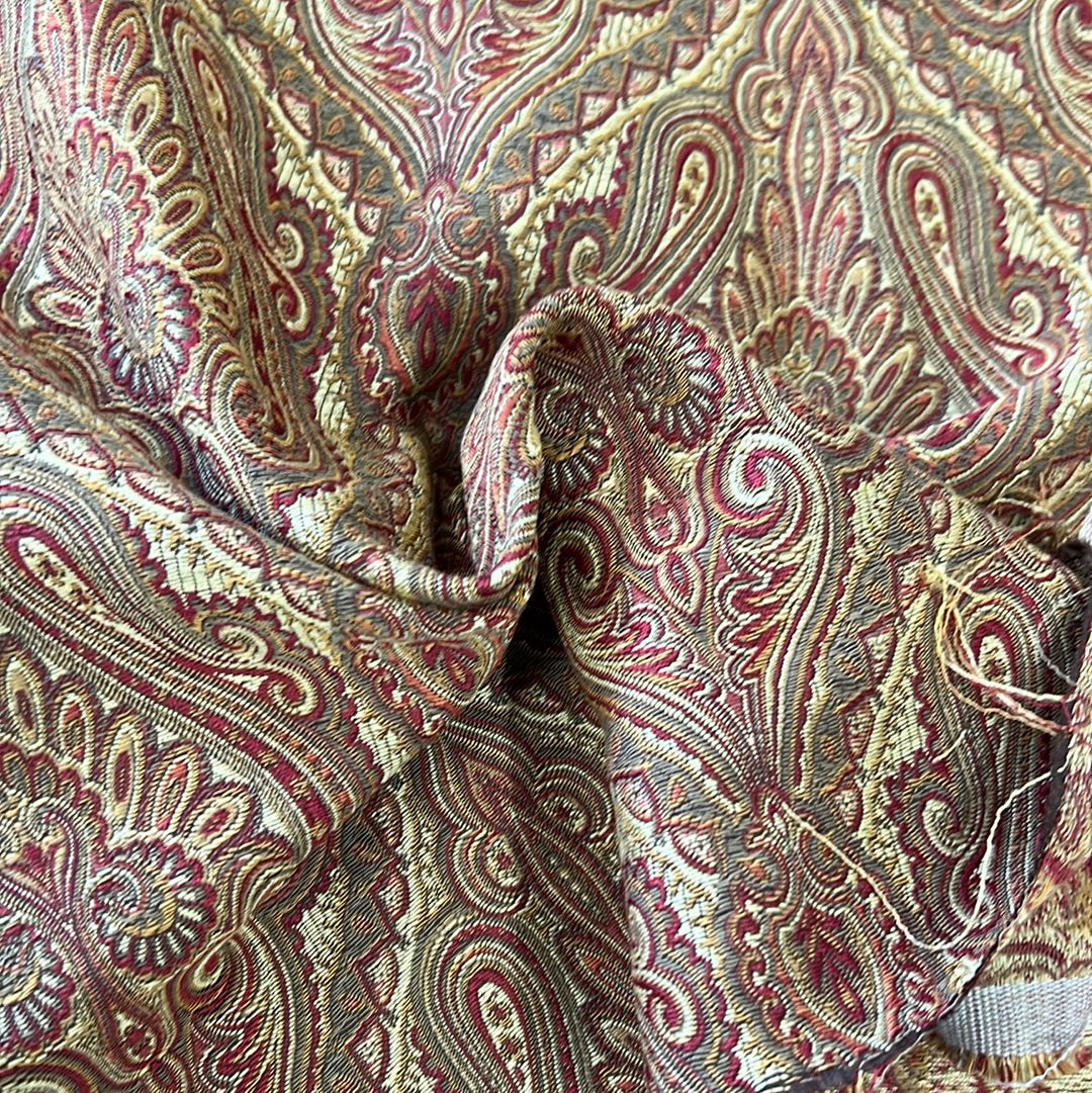 Burgundy and gold paisley patterned upholstery fabric sample.