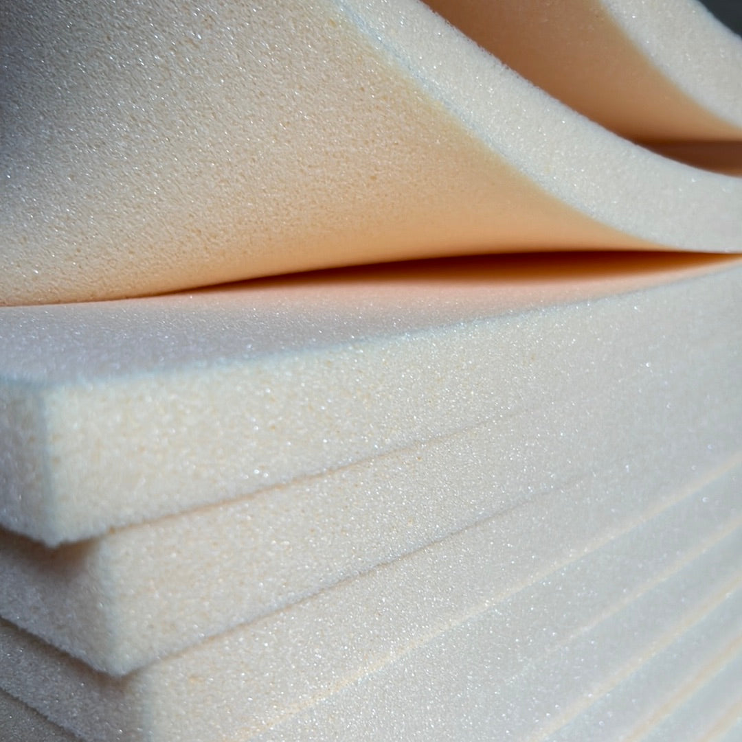 Cream-colored, extra-firm foam sheets stacked for cushioning applications.