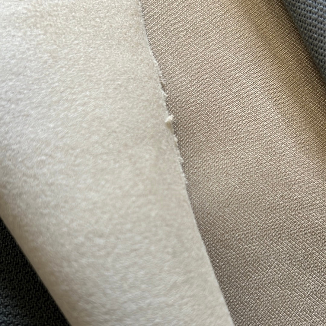Close-up of beige fabric swatches, showing texture and subtle color variations.
