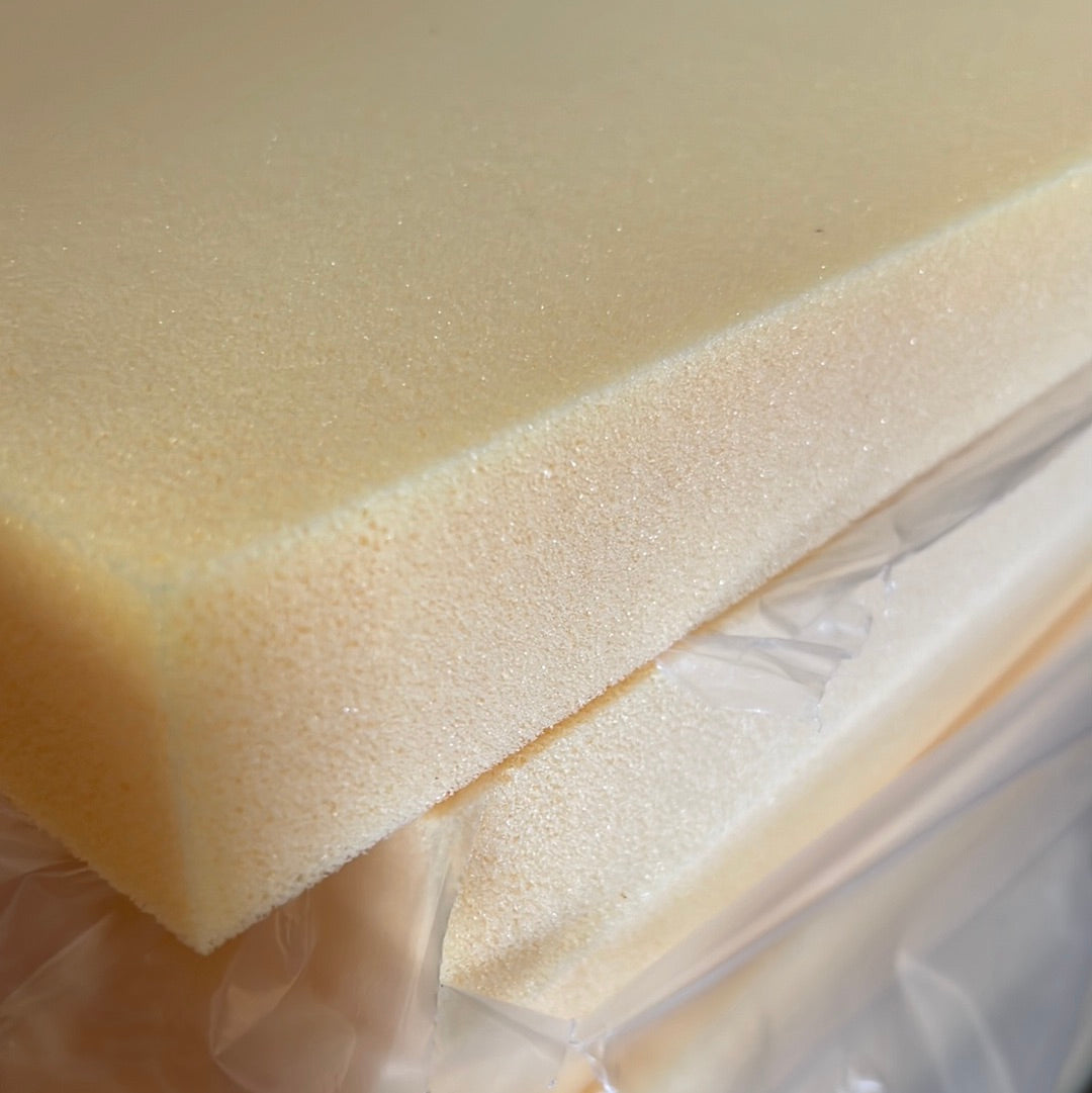 High-density foam sheets, extra firm HR60, in pale yellow, stacked and wrapped in plastic.