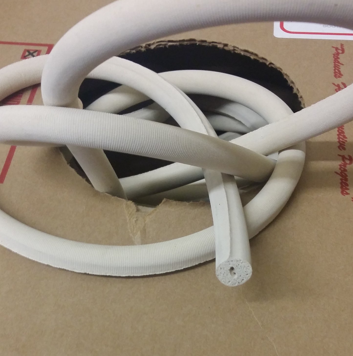 Off-white 1/2" sponge rod rubber cord in cardboard box.