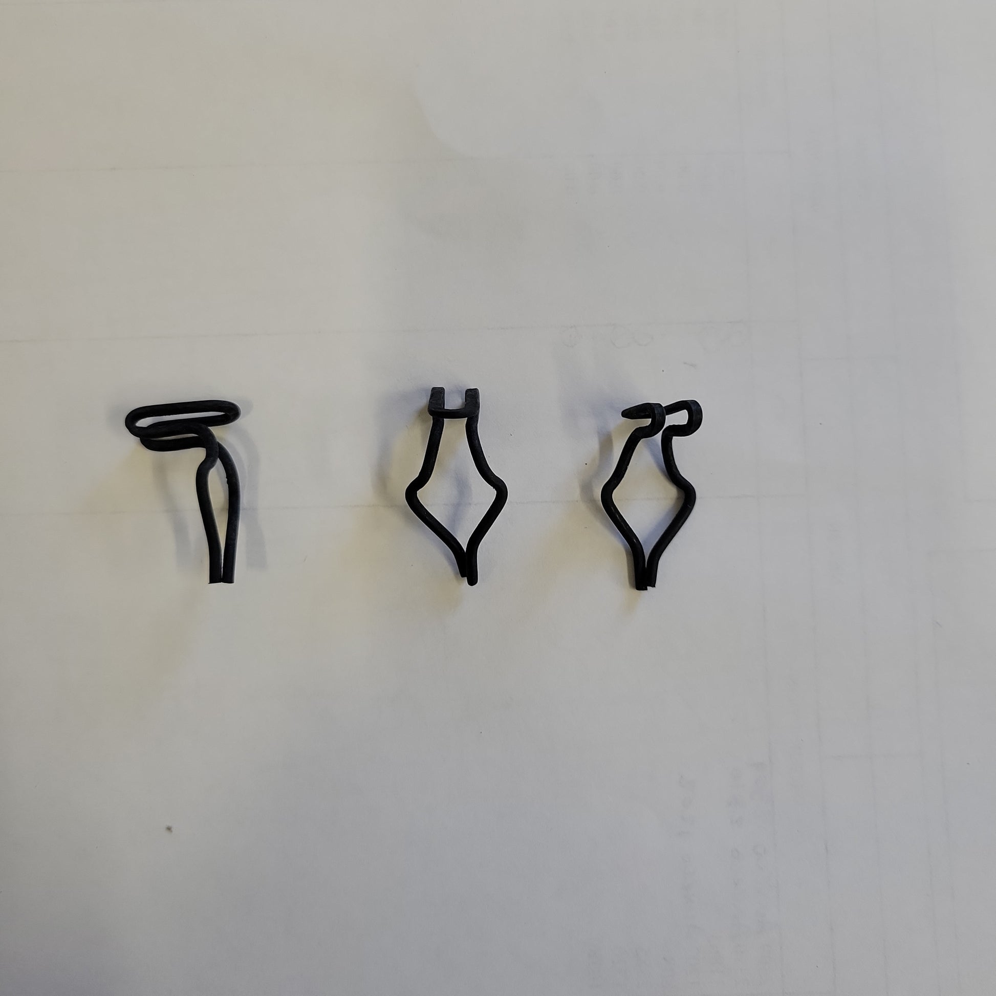 Black plastic clips against a white background.