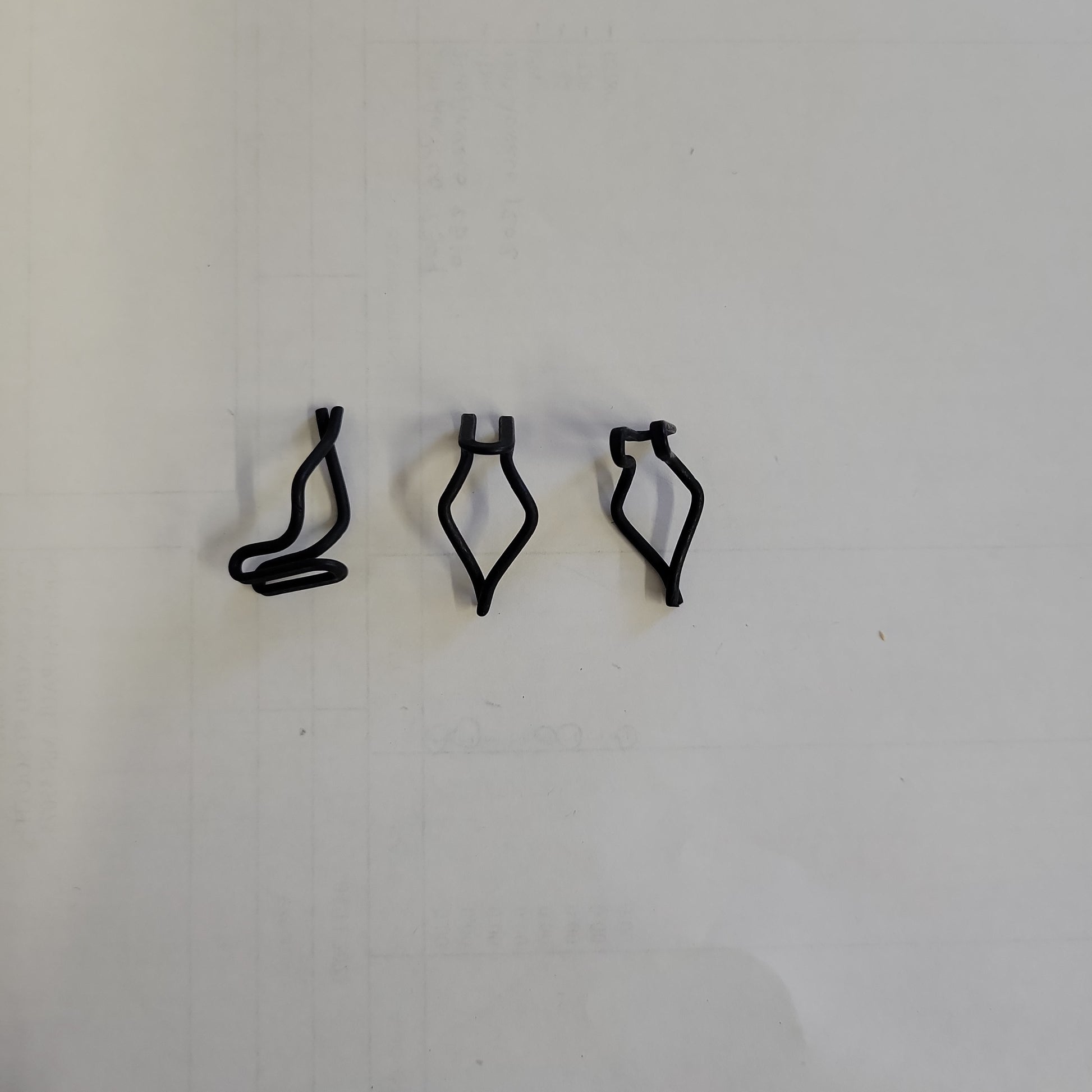 Three black plastic fasteners shown against a white background.
