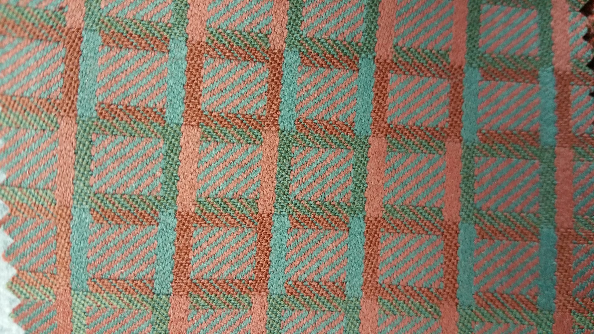 Geo III Pattern Fabric: Teal and coral geometric textile with a woven plaid design.