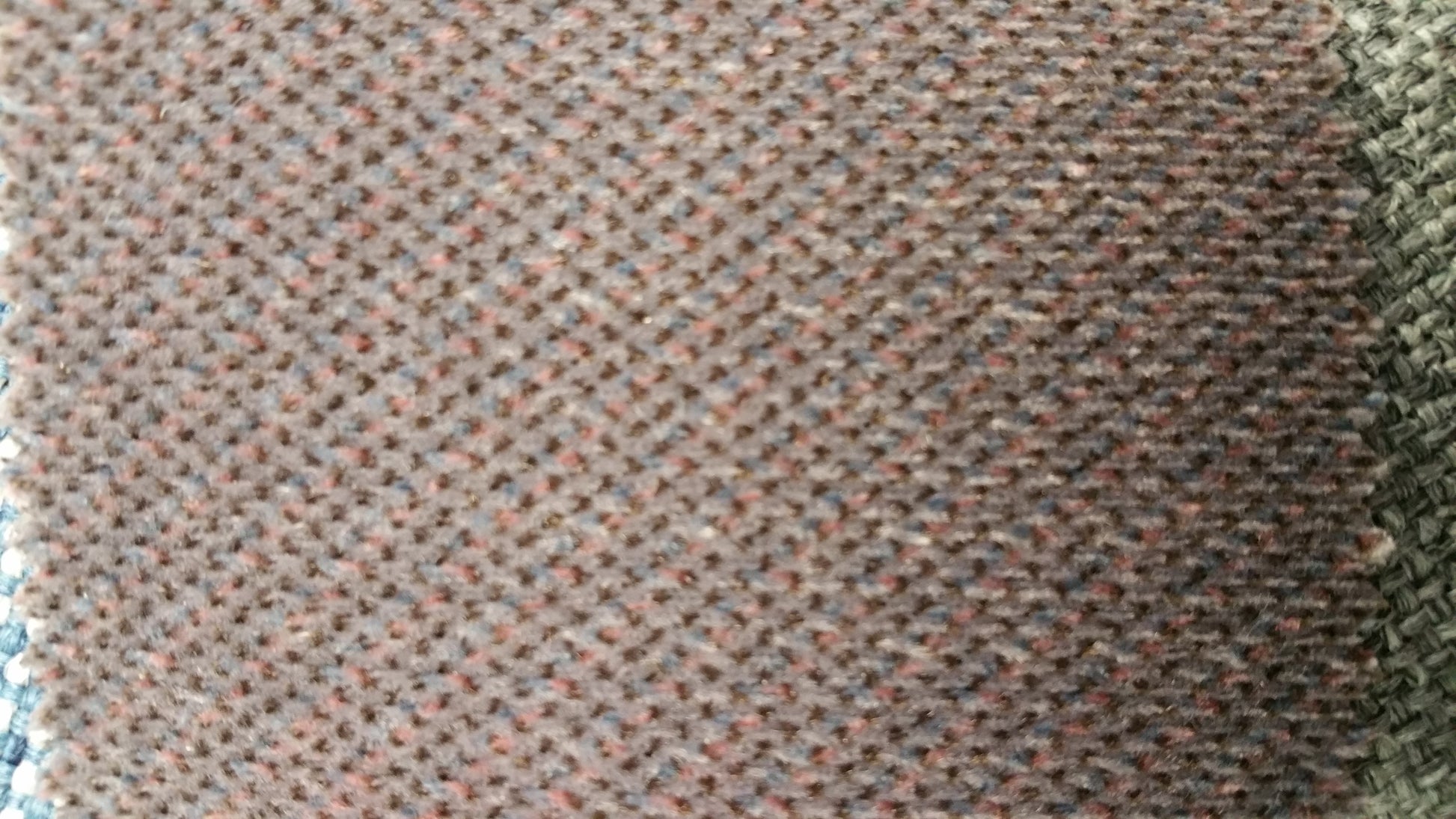 Ring 861 Contract Fabric: Close-up of textured brown fabric with hints of blue and pink threads.