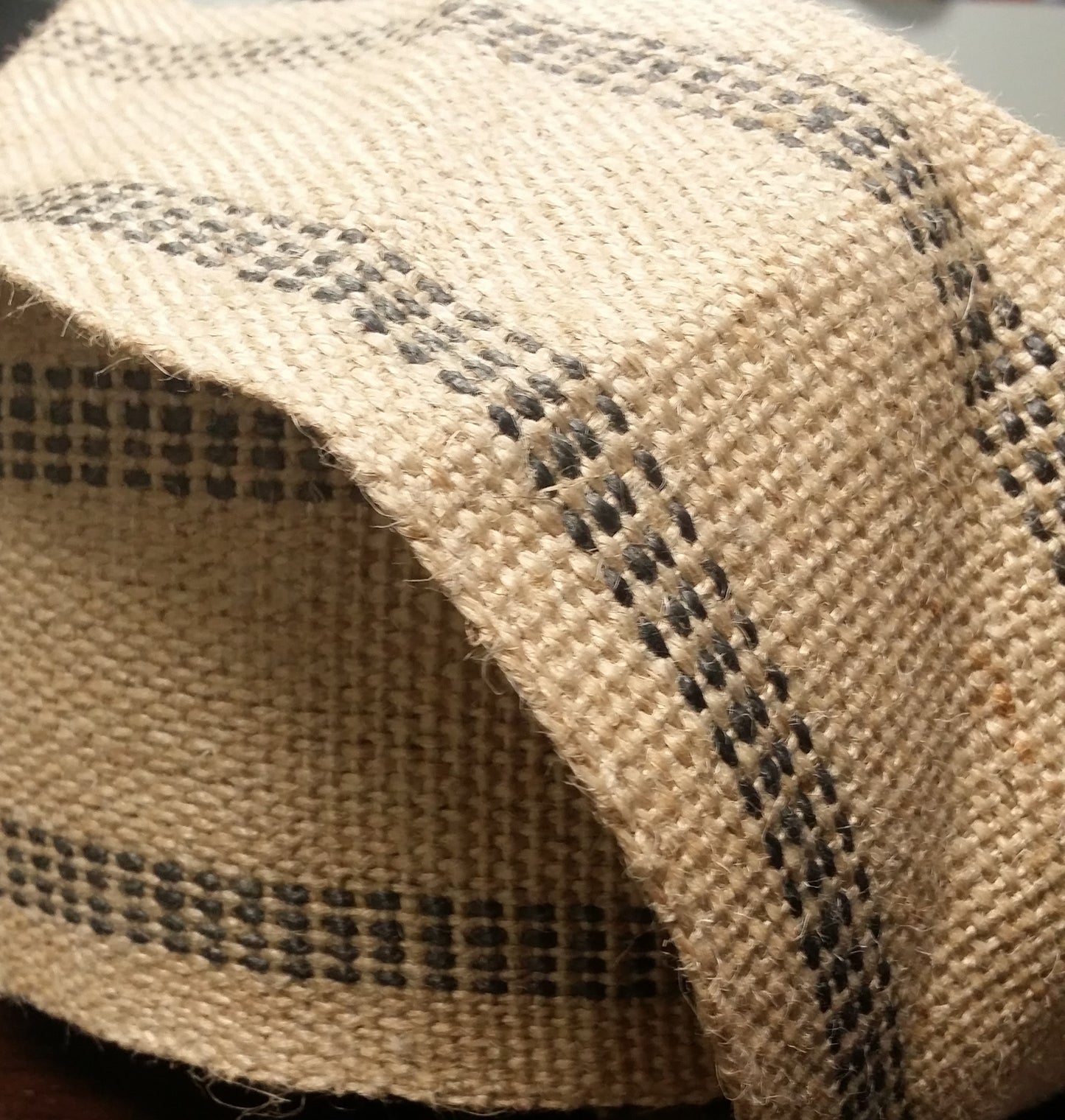 Natural jute webbing roll, 72 yards, black stitch detail.