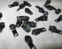 Black zipper slides for clothing repair; assorted quantity.