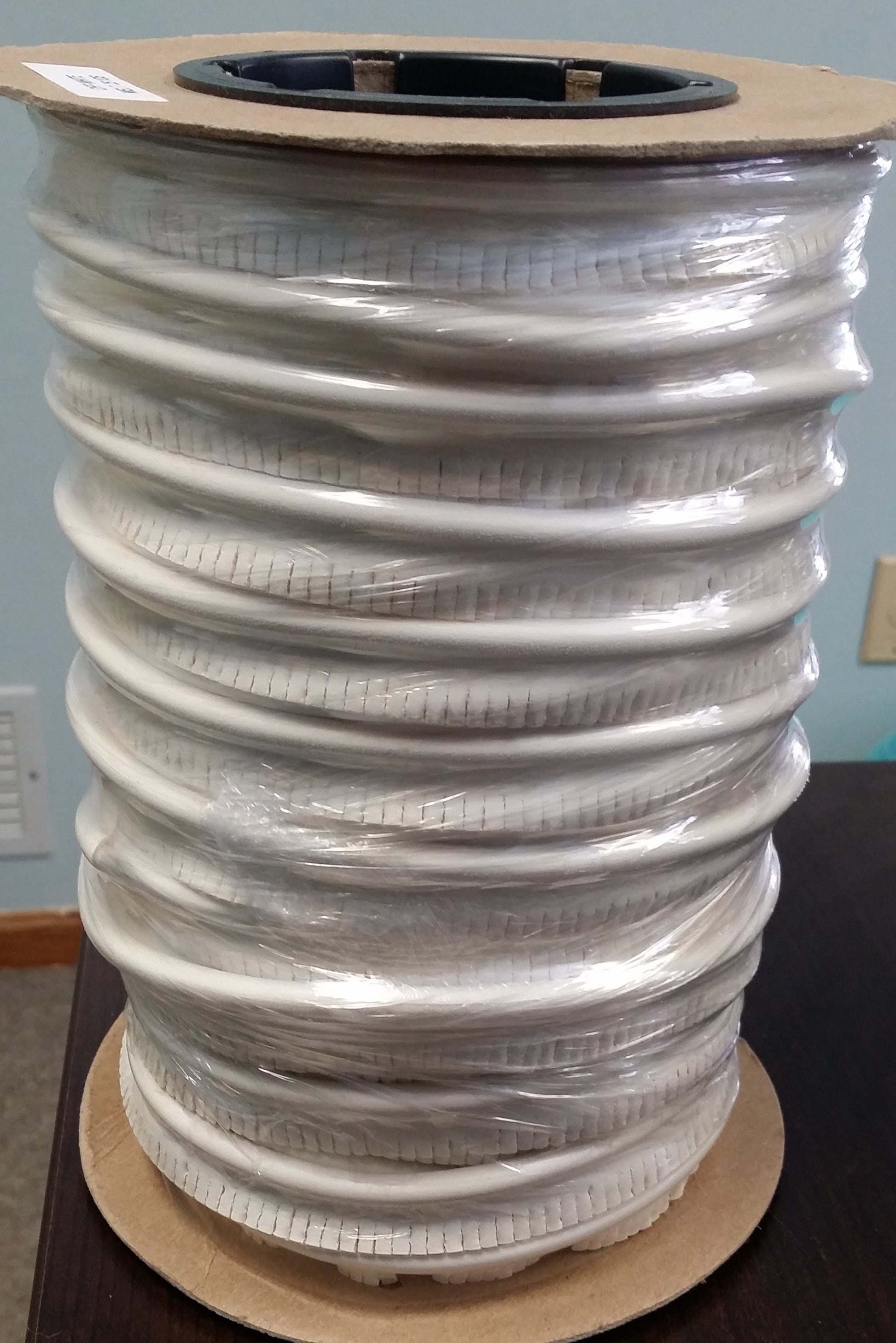 Off-white embossed cushion vinyl welt cord, 25-yard roll.