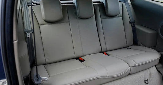 Light gray leather-look rear car seats in a vehicle interior