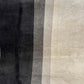 Striped upholstery fabric sample in shades of gray and black.