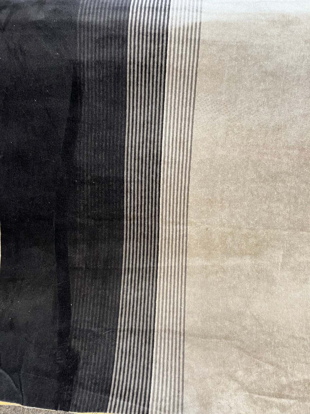 Striped upholstery fabric sample in shades of gray and black.