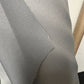 Close-up of gray automotive fabric swatch, showing texture and weave detail.