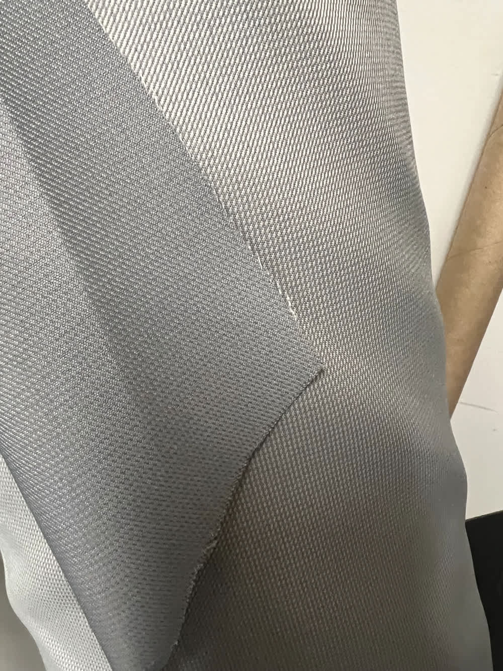 Close-up of gray automotive fabric swatch, showing texture and weave detail.
