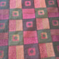 Burgundy quilted fabric in a patchwork design with dark olive green and gold accents.
